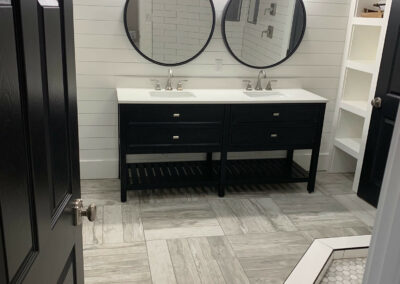 A-bathroom-featuring-a-sink-and-mirrors.-The-photograph-seems-to-focus-on-the-interior-design-of-the-bathroom-including-the-wall-floor-and-cabinetry