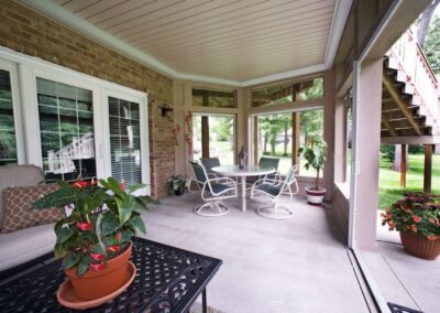 An-inviting-sunroom-furnished-with-comfortable-patio-seating-and-a-table-ideal-for-unwinding-and-savoring-the-outdoor-ambiance