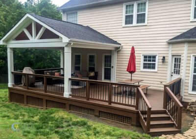 Covered-porch-with-a-wooden-deck-and-stone-patio
